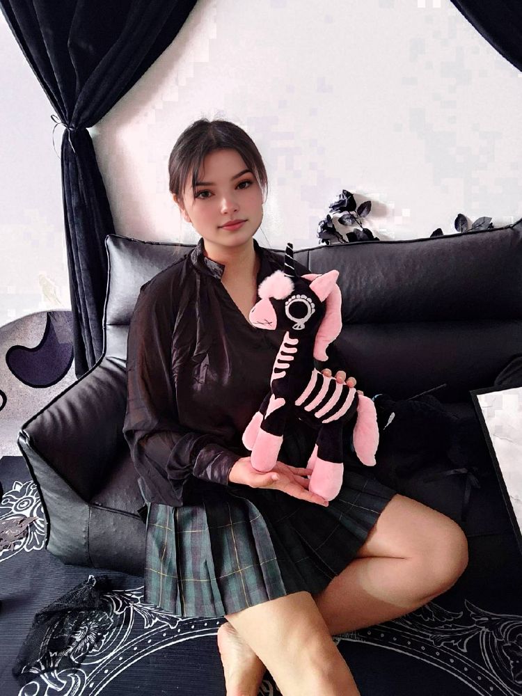 ピンクのスケルトンユニコーンを抱える女の子