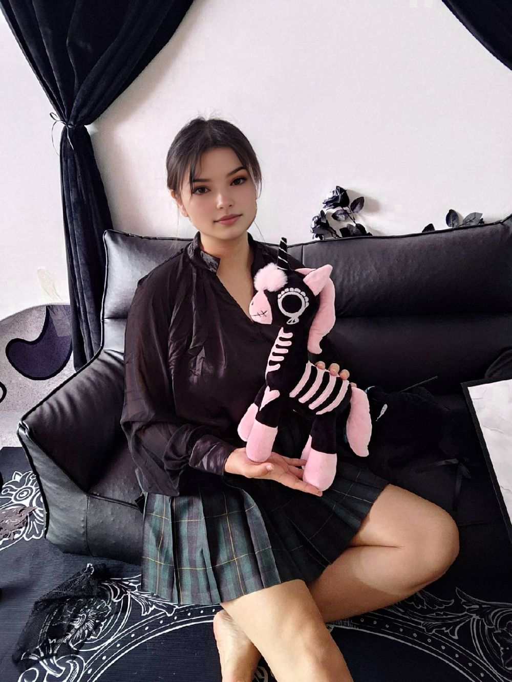 ピンク・スケルトン・ユニコーンぬいぐるみを抱えている女の子